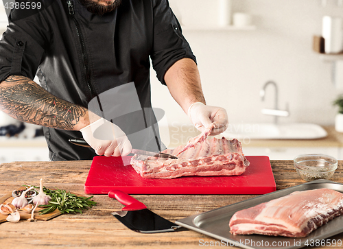 Image of Man cooking meat steak on kitchen