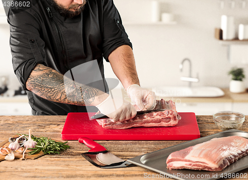 Image of Man cooking meat steak on kitchen