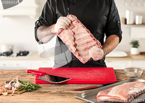 Image of Man cooking meat steak on kitchen