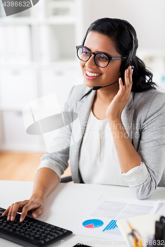 Image of businesswoman with headset and keyboard at office