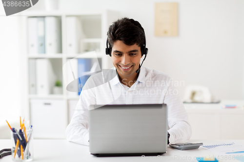 Image of businessman with headset and laptop at office