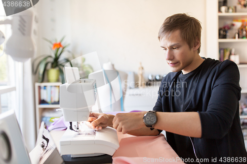 Image of fashion designer with sewing machine at studio