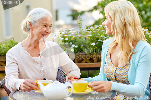 Image of daughter with senior mother drinking tea at cafe