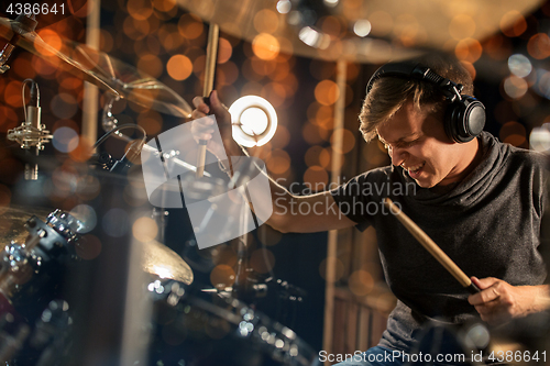 Image of male musician playing drum kit at concert