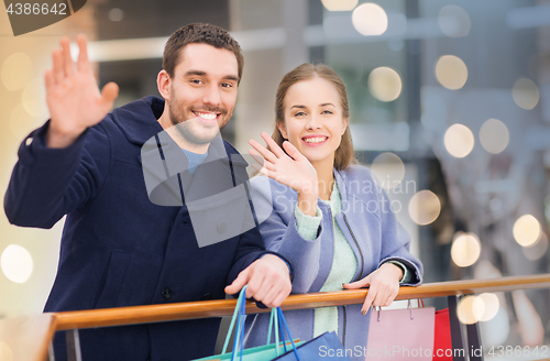 Image of happy young couple with shopping bags in mall