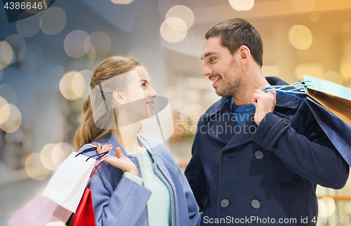 Image of happy young couple with shopping bags in mall