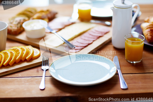 Image of plate and glass of orange juice on table with food