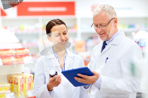 Image of apothecaries with tablet pc and drug at pharmacy