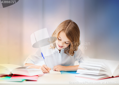 Image of student girl with books writing in notebook