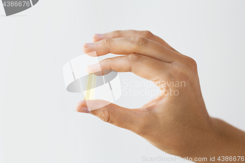 Image of hand holding cod liver oil capsules