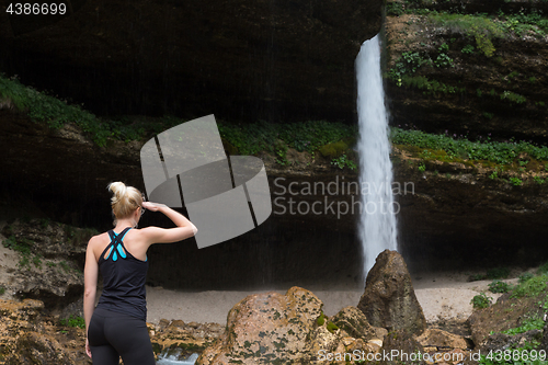 Image of Active woman looking at Pericnik waterfall in Vrata Valley in Triglav National Park in Julian Alps, Slovenia.