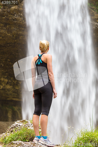 Image of Active woman looking at Pericnik waterfall in Vrata Valley in Triglav National Park in Julian Alps, Slovenia.