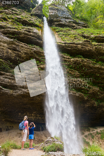 Image of Active tourists looking at Pericnik waterfall in Vrata Valley in Triglav National Park in Julian Alps, Slovenia.