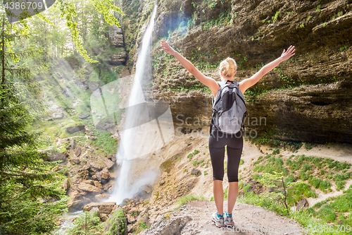 Image of Active woman raising arms inhaling fresh air, feeling relaxed in nature.