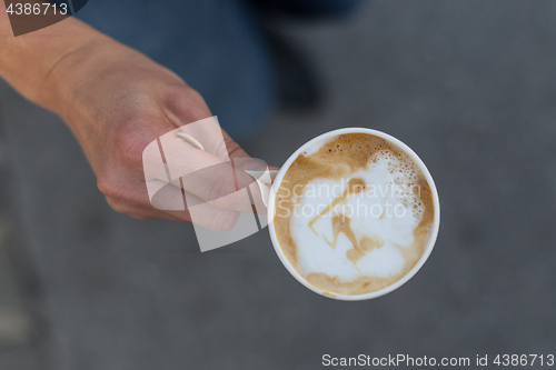 Image of Hand holding a cup of coffee to go.