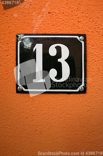 Image of the number thirteen on an orange wall