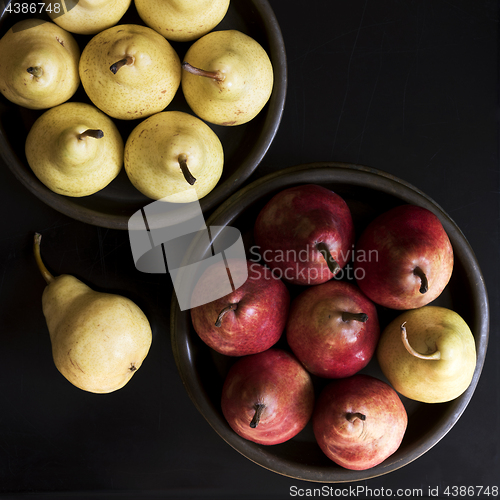 Image of Several yellow and red pears in bowls