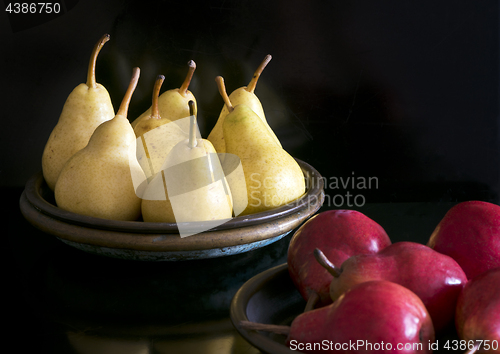Image of Several yellow and red pears in bowls