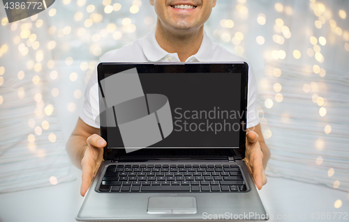 Image of close up of happy man showing laptop