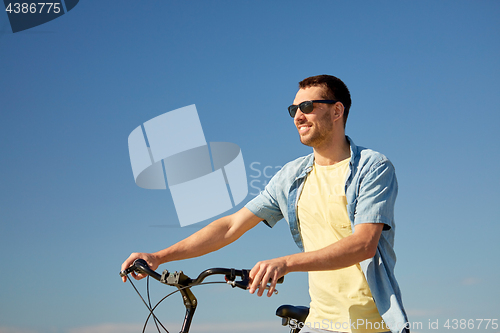 Image of happy smiling man with bicycle outdoors