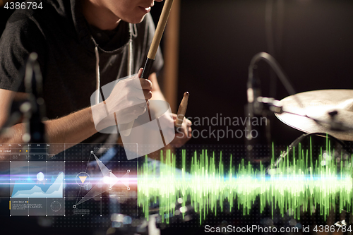 Image of male musician playing drum kit at concert