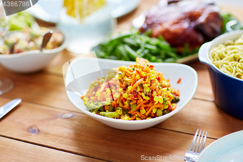 Image of vegetable salad with corn and other food on table