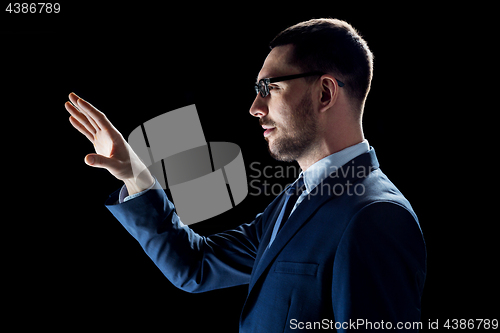 Image of businessman in suit over black