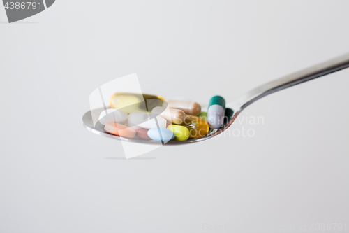 Image of different pills and capsules of drugs on spoon