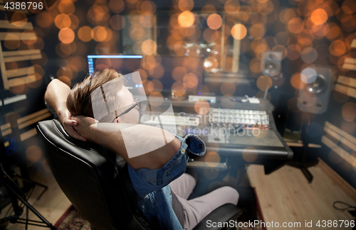 Image of man at mixing console in music recording studio