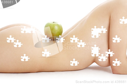 Image of puzzle of woman torso with green apple