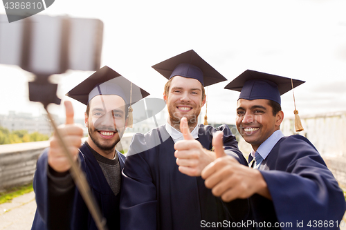 Image of happy male students or graduates taking selfie