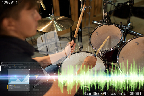 Image of male musician playing drum kit at concert