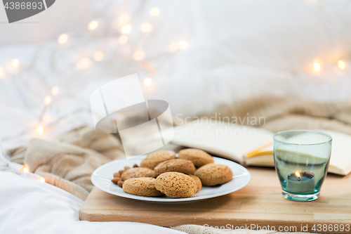 Image of oatmeal cookies and candle in holder at home