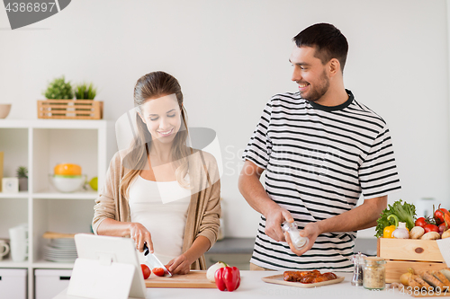 Image of happy couple cooking food at home kitchen