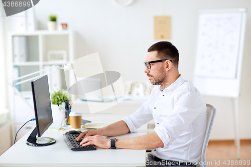 Image of businessman typing on computer keyboard at office