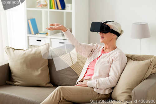 Image of old woman in virtual reality headset or 3d glasses