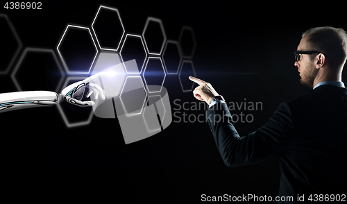 Image of businessman and robot touching network hologram
