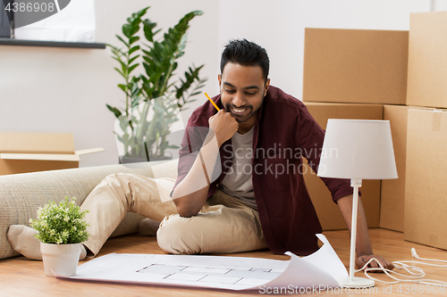 Image of man with blueprint and boxes moving to new home