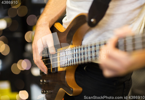 Image of close up of musician with guitar at music studio