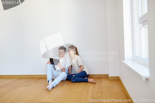 Image of happy couple with tablet pc computer at new home