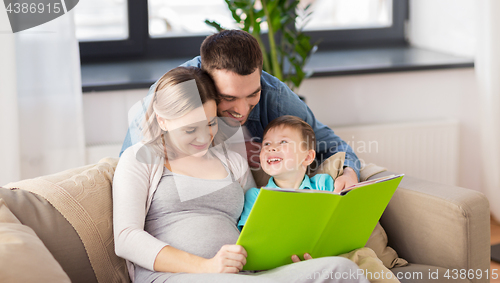 Image of happy family reading book at home