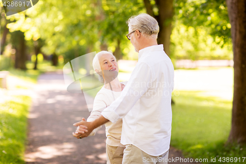 Image of happy senior couple dancing at summer park