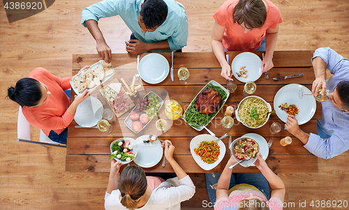 Image of group of people eating at table with food