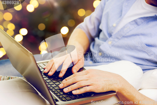 Image of close up of man typing on laptop keyboard