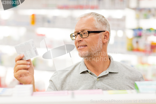 Image of senior male customer with drug at pharmacy