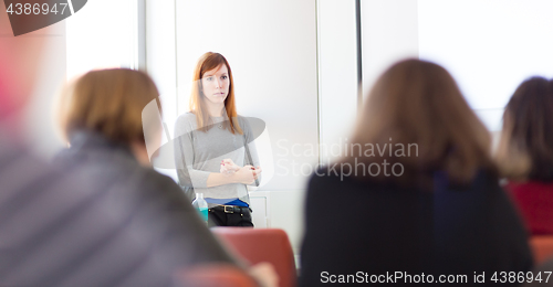 Image of Woman giving presentation in lecture hall at university.