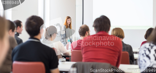 Image of Woman giving presentation in lecture hall at university.