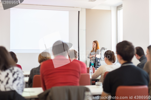 Image of Woman giving presentation in lecture hall at university.