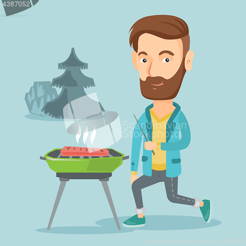 Image of Man cooking steak on barbecue grill.