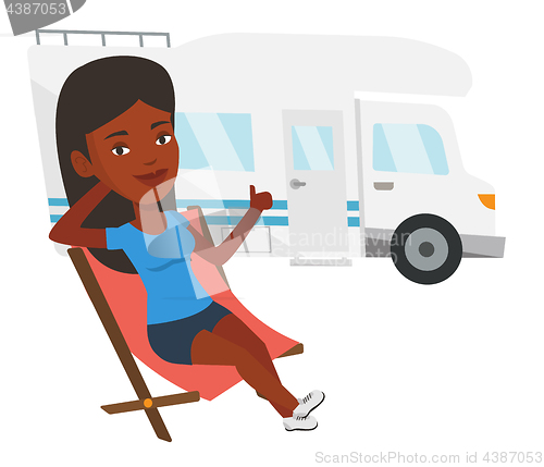 Image of Woman sitting in chair in front of camper van.